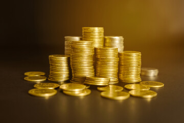 Pile of golden money coin on wood desk and black background. Business and financial concept. 