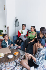 Group of latin LGBT friends eating pizza, drinks and having fun at home in Mexico, Hispanic homosexual and lgbtq community in Latin America in party	