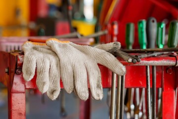 white gloves placed on red tool cart in a garage. creating a focus on the cleanliness and readiness...