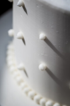 Closeup detail of a swiss dotted white wedding cake