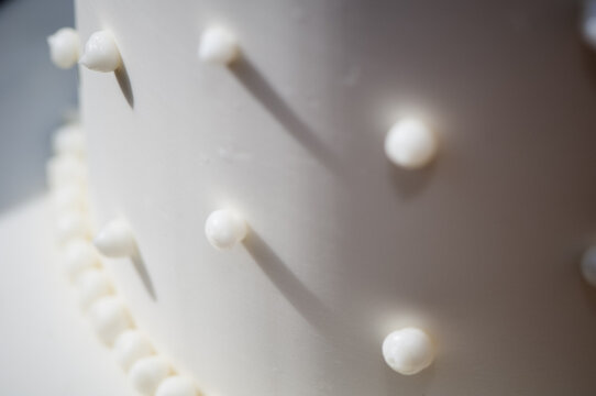 Closeup detail of a swiss dotted white wedding cake