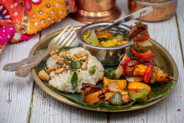 Air fried vegan barbeque  seitan and vegetables skewers served on banana leaf along with Indian pongal and sambar