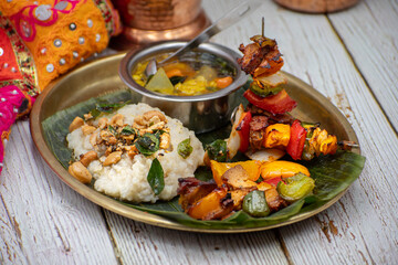 Air fried vegan barbeque  seitan and vegetables skewers served on banana leaf along with Indian pongal and sambar