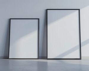 Two empty white frames with dark borders, each spotlighted in a state-of-the-art architectural studio against a light gray wall. 