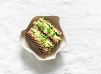 Delicious breakfast, brunch, snack - wholegrain sandwich with avocado, scrambled eggs and...