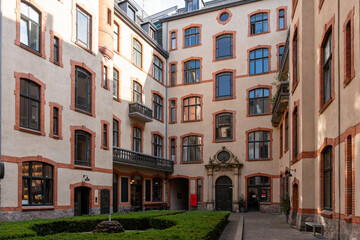 Courtyard with a brick building and a red sign. Courtyard of an old building.