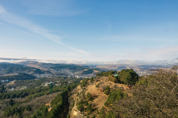 A beautiful landscaped park with benches, paths and green lawns, a gazebo in the morning in the fog.