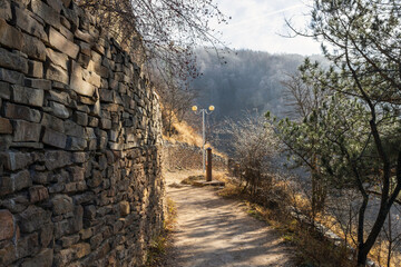 A beautiful landscaped park with benches, paths and green lawns.