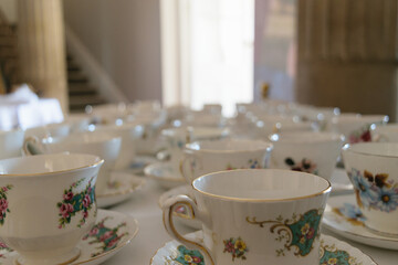 Ornate porcelain teacups with floral designs on a table