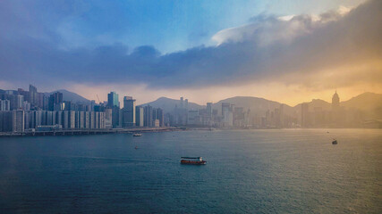 Fototapeta premium Panoramic skyline silhouette view of Hongkong Hong Kong Victoria Harbor and port infrastructure bay scenic landscape seascape scenery during twilight blue hour in China