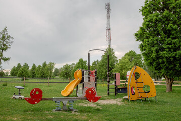 A colorful playground with a slide and swings is located in the park