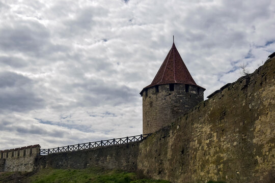 Old Stone Fortress With Conical Tower Under Cloudy Sky in Springtime. Copy space. Selective focus.