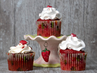 red cupcakes with white cream on wooden background