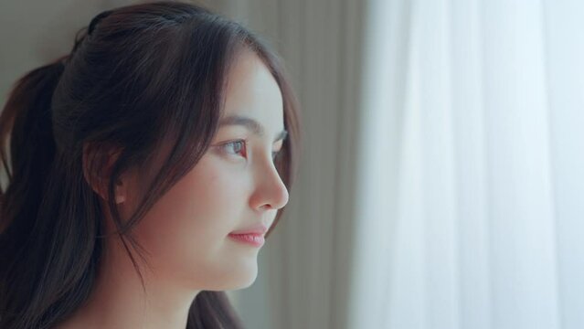 Close-up of eyes young asian woman opening and looking straight, Beautiful face of asian sensitive lady in apartment indoor, Enjoy moment of peace	