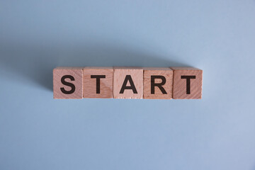 A row of wooden cubes with start text on the table. New beginning of life, business or career...