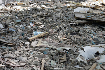 Construction waste. A pile of concrete debris with reinforcement, boards and pieces of wire after the destruction of the building. Demolition rubble. Industrial concept