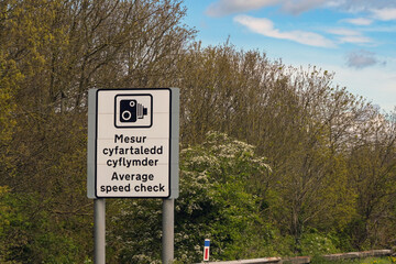 Speed camera symbol on a bilingual sign marking the start of an average speed check area on a motorway in Wales