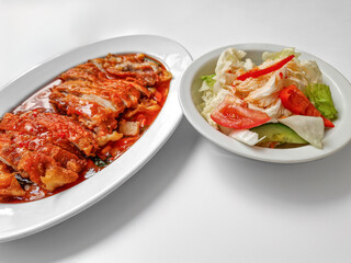 Chicken baked with onion in tomatoes with white cabbage salad.