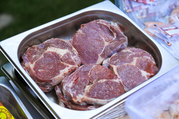 Raw seasoned steaks in a metal tray