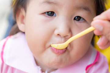 Child eating rice with a spoon close-up,Close up infant baby feeding food on the kid chair