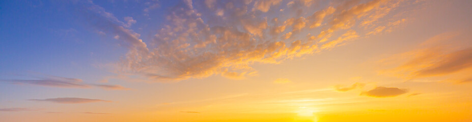 Clouds and orange sky,Real majestic sunrise sunset sky background with gentle colorful clouds without birds.Panorama, large