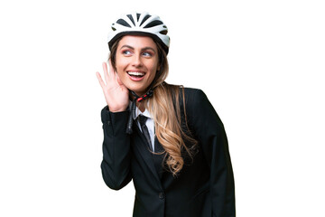 Business Uruguayan woman wearing a helmet biker over isolated background listening to something by putting hand on the ear