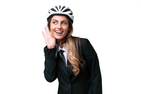 Business Uruguayan woman wearing a helmet biker over isolated background listening to something by putting hand on the ear