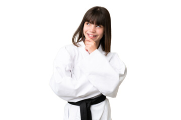 Little Caucasian girl doing karate over isolated background looking to the side