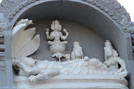 Bas-relief on a Hindu temple - Vishnu lies on the snake Anantashesha, a lotus grows from his navel in which Brahma sits, and Lakshmi massages his feet.