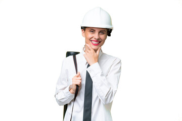 Young architect woman with helmet and holding blueprints over isolated background happy and smiling