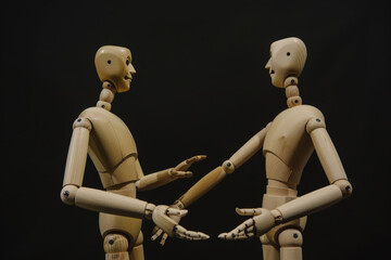 Obraz premium Wooden Mannequins Engaging in Discussion Against Black Background