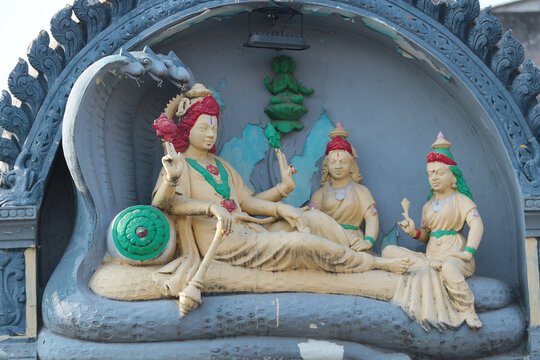 Vishnu lies on the snake Anantashesha, a lotus grows from his navel in which Brahma sits, and Lakshmi massages his feet.