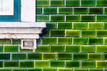 Green glazed tile on the facade of the house close up. Traditional glazed tile in Lisbon, Portugal.