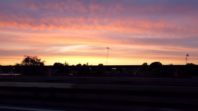 Newcomer's journey to London as capture video of street view of Sunset Twilight Silhouette clip from front of their car from Heathrow International Airport to bustling downtown district.