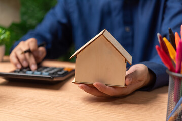 A man is holding a model house. Real estate buying and selling or leasing Making contracts for...