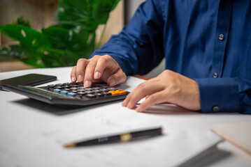 A man is working, using a calculator, doing accounting or financial transactions, banking or taxes.