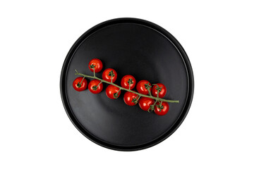 branch of tomatoes on a black plate top view isolated on white
