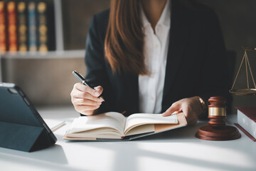 Thoughtful businesswoman is in a legal office with a gavel on her desk. She looks pensive and focused, indicating a deep involvement in her legal work and responsibilities.