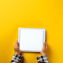Child's Hands Holding White Blank Screen Tablet Computer on Yellow Background, 