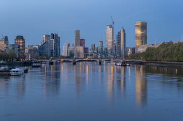 Westminster Palace and Vauxhall skyscrapers over River Thames in the blue hour, London, United Kingdom
