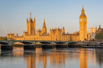 Early sunny morning with Palace of Westminster and Big Ben clock tower seen across River Thames, London, United Kingdom