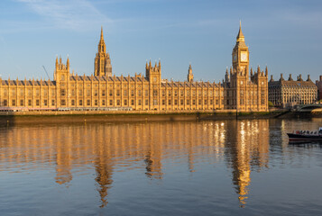 Early sunny morning with Palace of Westminster and Big Ben clock tower seen across River Thames, London, United Kingdom