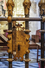 Antique lattice lock, light colored background, medieval, keyhole and peghead. Bronze and black metal.