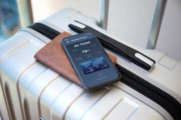 phone with air ticket application on screen suitcases at airport