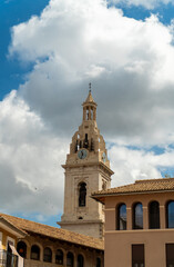 Fototapeta premium Bell tower in Xativa old town, against blue cloudy sky