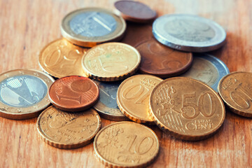 Euro Coin Assortment. Various Euro coins on wood, showcasing currency. Uses forFinancial blogs, currency exchange sites.