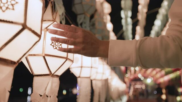 Woman hand touching on paper lanterns Lanna style in Loy Krathong festival