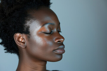 A close up of a black woman's face with her eyes closed looking to a side