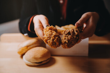 close up focus woman hand hold fried chicken for eat,girl with fast food concept