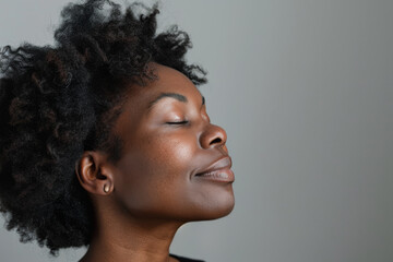 Obraz premium A close up of a black woman's face with her eyes closed looking to a side